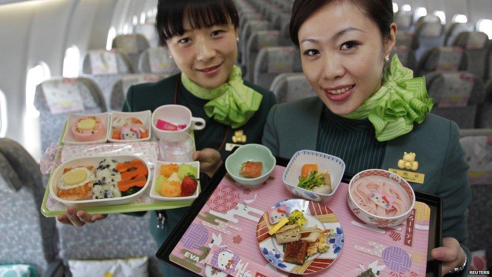 Two flight attendants holding the on board food