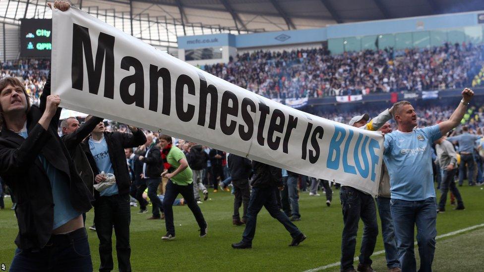 Manchester City fans celebrate on the pitch