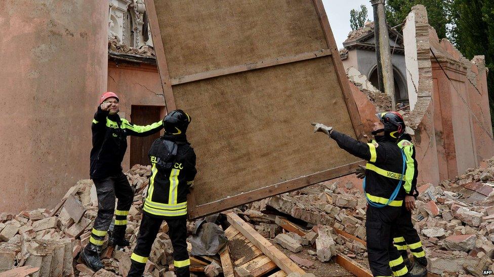 Firemen recover a painting from a destroyed church in the village of San Carlo after an earthquake shook downtown Finale Emilia.