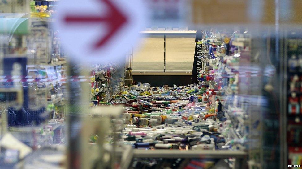 Hundreds of products lie on the floor in a supermarket after being shaken to the floor by the earthquake.