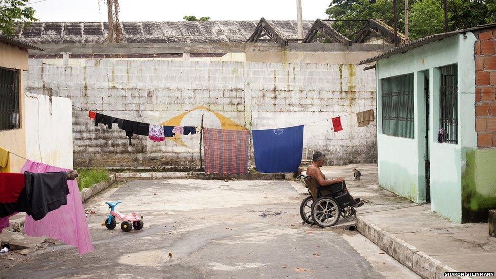 A man wheels into his home in the surrounding neighbourhood at Colonia Antonio Aleixo in Manaus