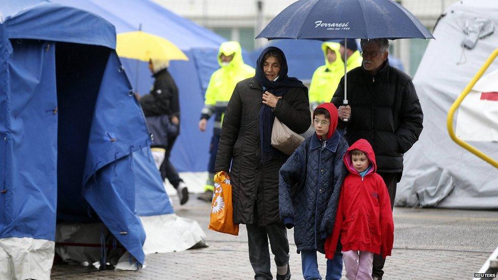 A family walks in an emergency tents camp in Finale Emilia May 21, 2012.