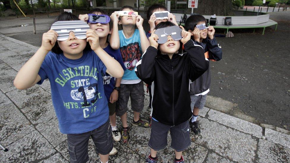 Children watch an annular solar eclipse in Fujisawa, near Tokyo.