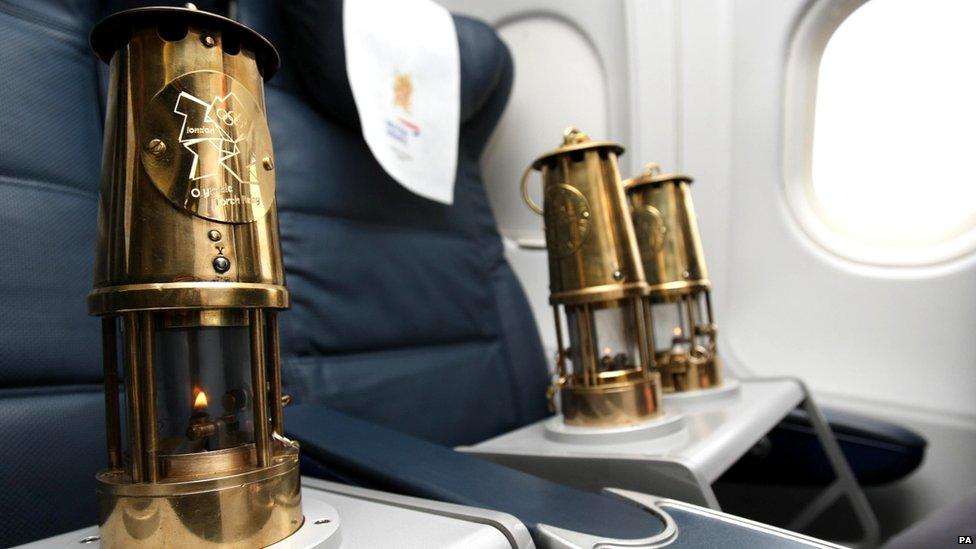 The Olympic flame in lanterns, secured into aeroplane seats
