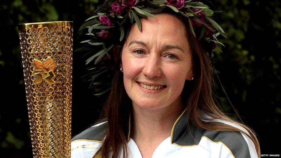 Olympic torchbearer Sarah Milner Simonds poses with her Olympic torch that she has already sold on an online auction site