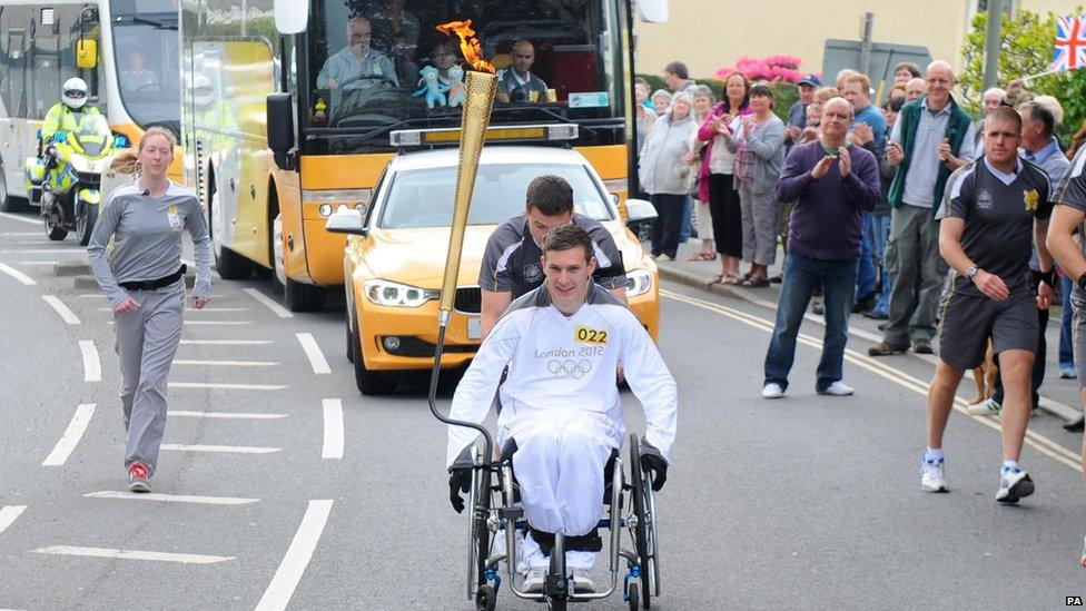 David Follett carrying the Olympic torch on the leg between Torrington and Bideford.