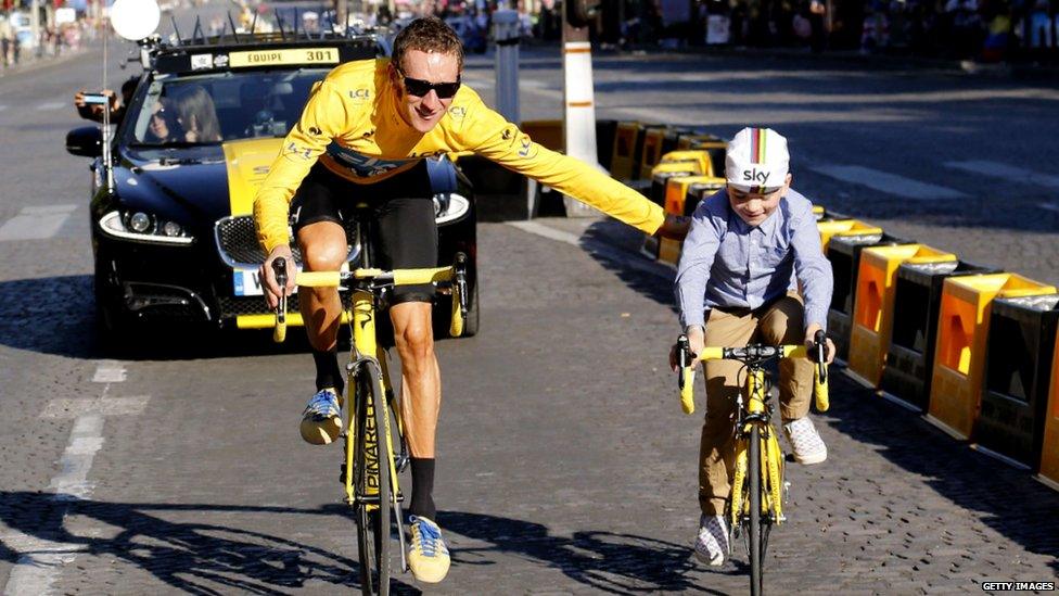 Overall leader in the yellow jersey, British Bradley Wiggins parades with his son at the end of the Tour de France. The cycling race started in Rambouillet and finished in the famous Paris-Champs-Elysees Avenue, on July 22, 2012.