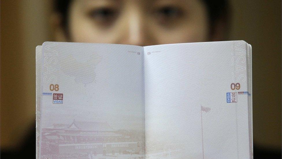 A woman holds the new Chinese passport on 23 November 2012