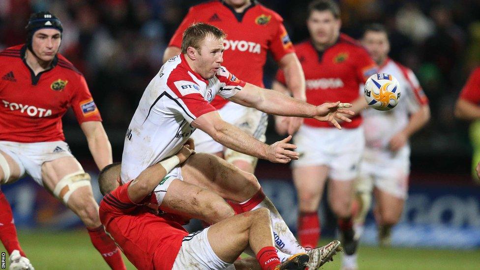 Ulster skipper Roger Wilson gets his pass away despite Munster pressure