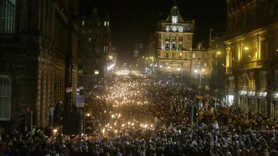 People take part in a torchlight procession through Edinburgh as part of the pre Hogmanay celebrations.