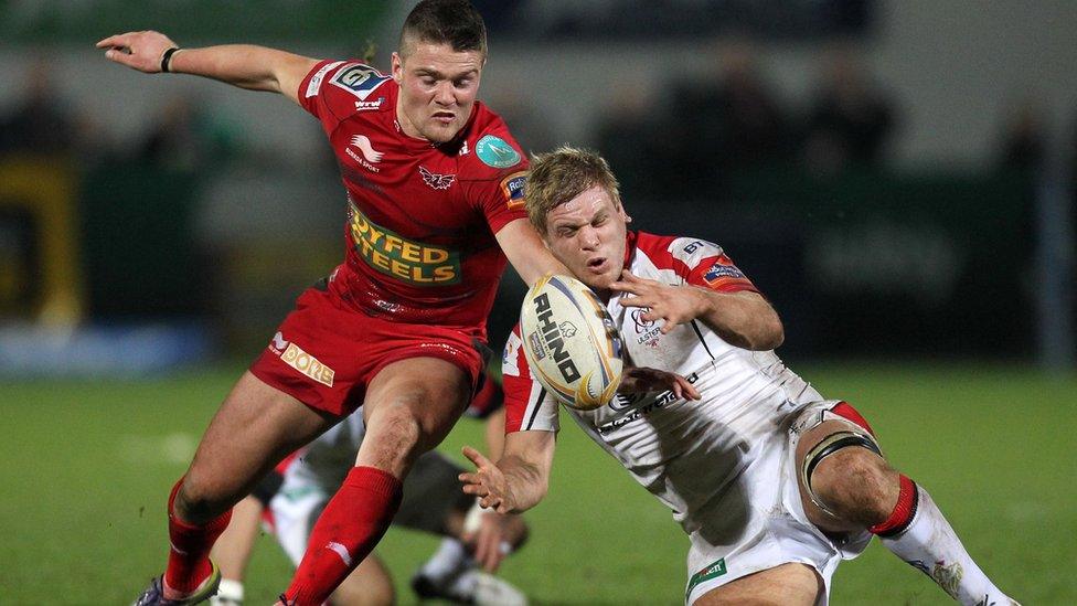 Scarlets scrum-half Tavis Knoyle attempts to get the ball before Ulster skipper Chris Henry at Ravenhill