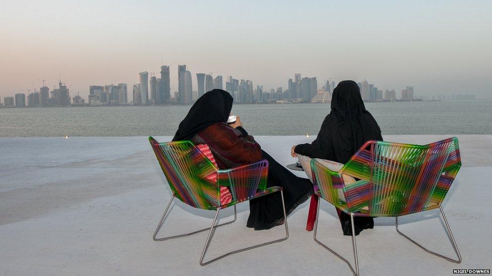 Two Qatari women drinking 'designer' coffee on a winter's evening at the Museum of Islamic Art park overlooking West Bay, Doha.