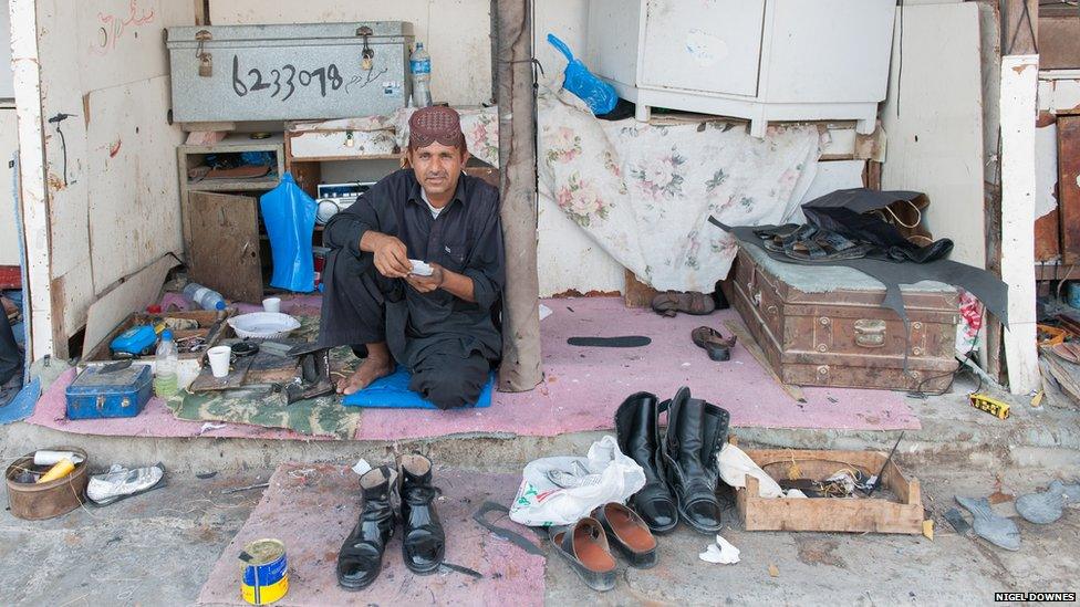 Away from the city centre with its polish and glitz it is still possible to find traditional crafts workers. Here a cobbler repairs shoes in a quieter suburb of Doha.