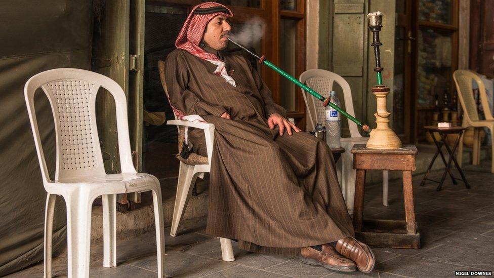 Qatari gentleman relaxing in the Souk smoking his Shisha pipe.