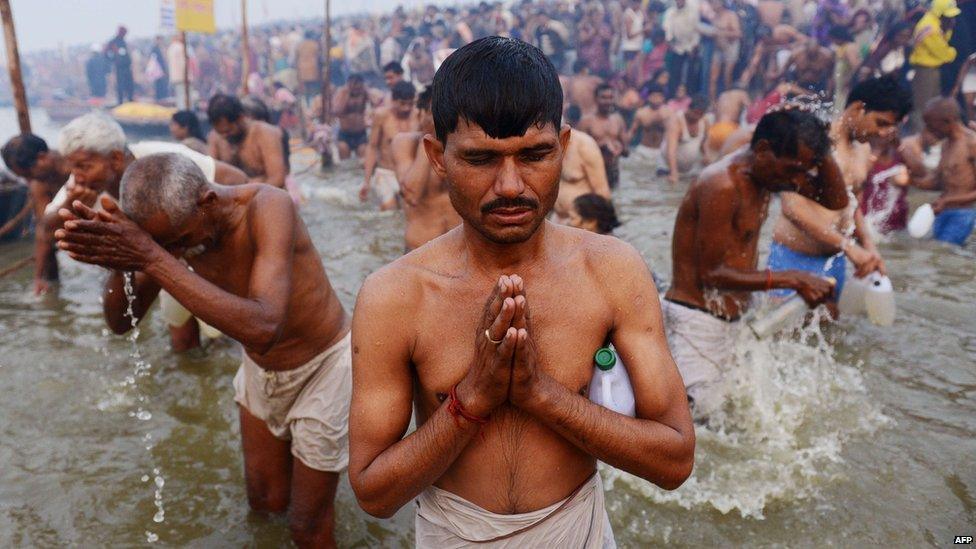 Hindu devotees pray in the waters of the Sangham or the confluence of the the Yamuna and Ganges rivers during the Kumbh Mela in Allahabad