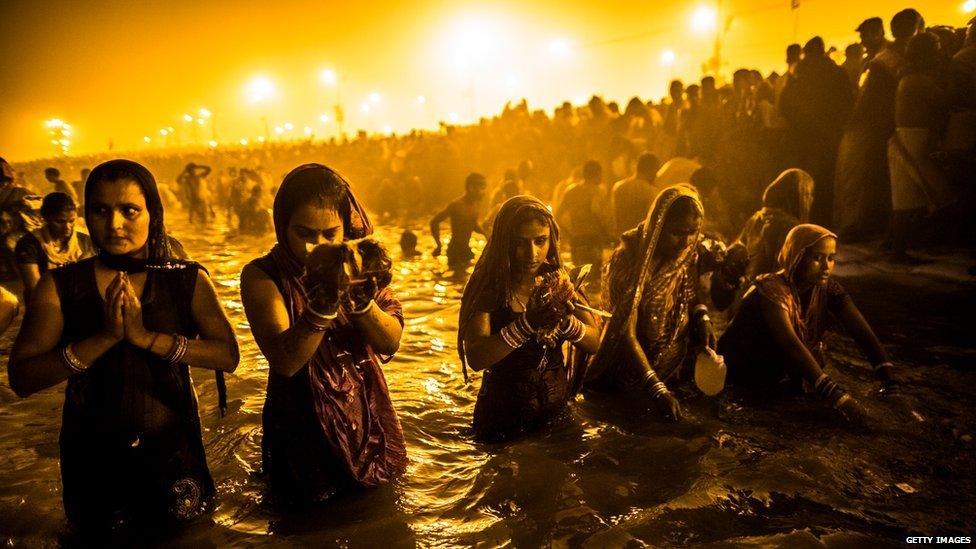 Hindu devotees bathe in the waters of the Ganges in Allahabad, India, 14 January 2013