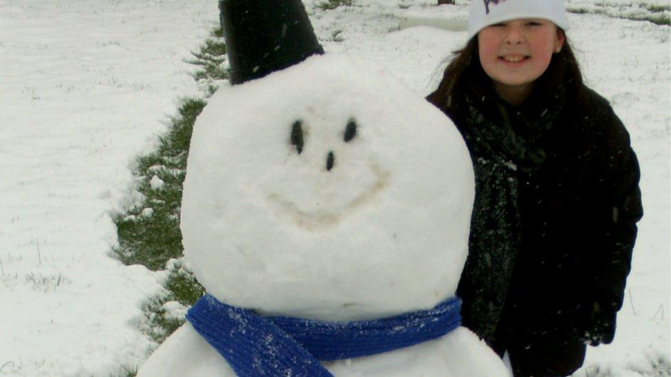 A girl and her snowman.