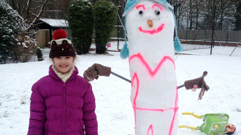 A snow woman sprayed with pink luminous paint.