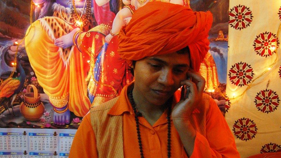 Devya Giri, leader of the new women's order on a mobile phone