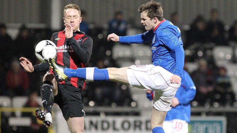 Crusaders striker Timmy Adamson is beaten to the ball by Linfield defender Niall Quinn beats in the Irish Cup fifth round replay at Seaview