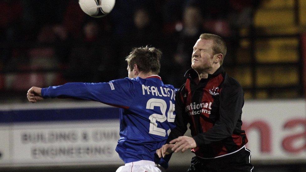 Linfield's Mark McAllister is challenged for the ball by Crusaders defender Davy Magowan