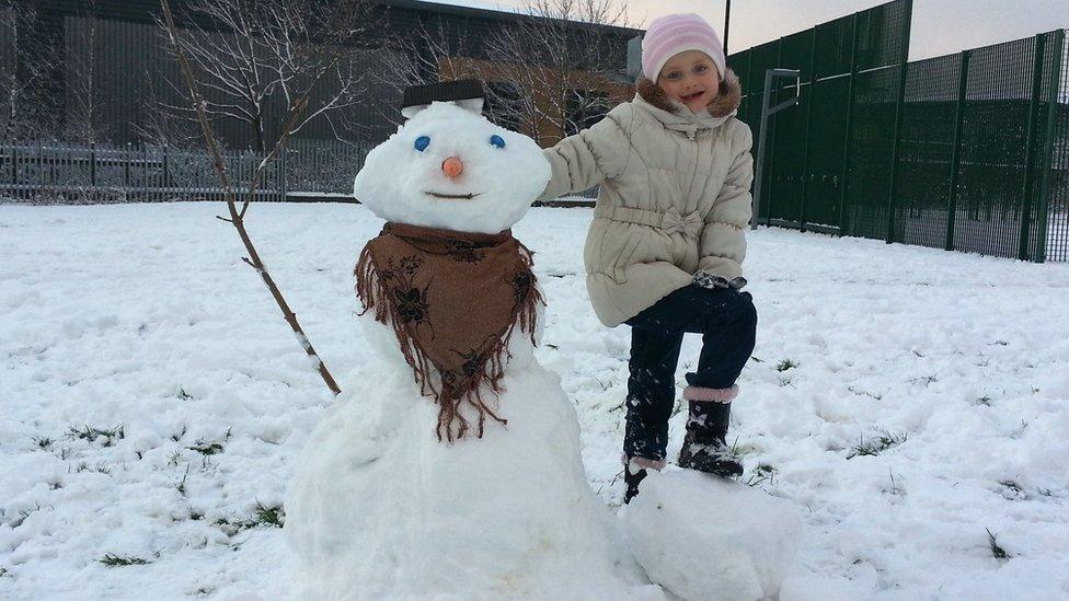 A girl with her snowman.