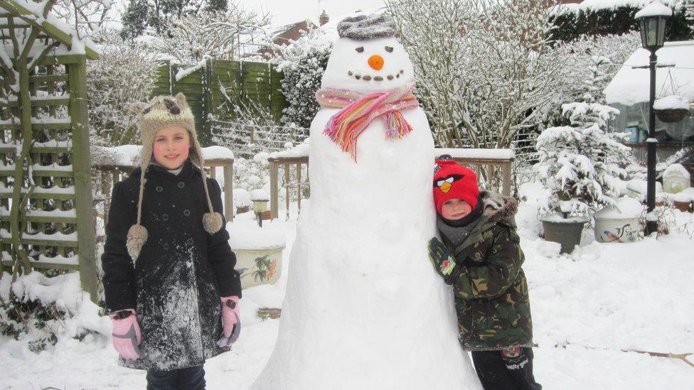 Two children with their snowman.