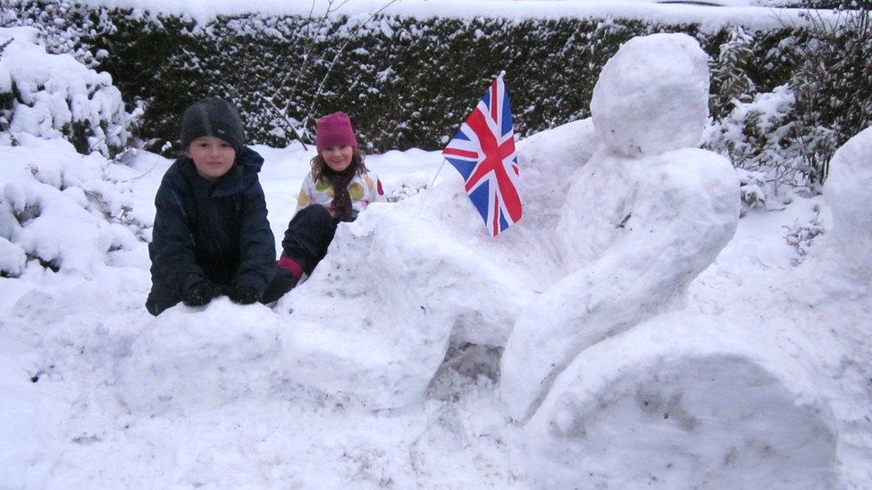 Two children with a snowman.