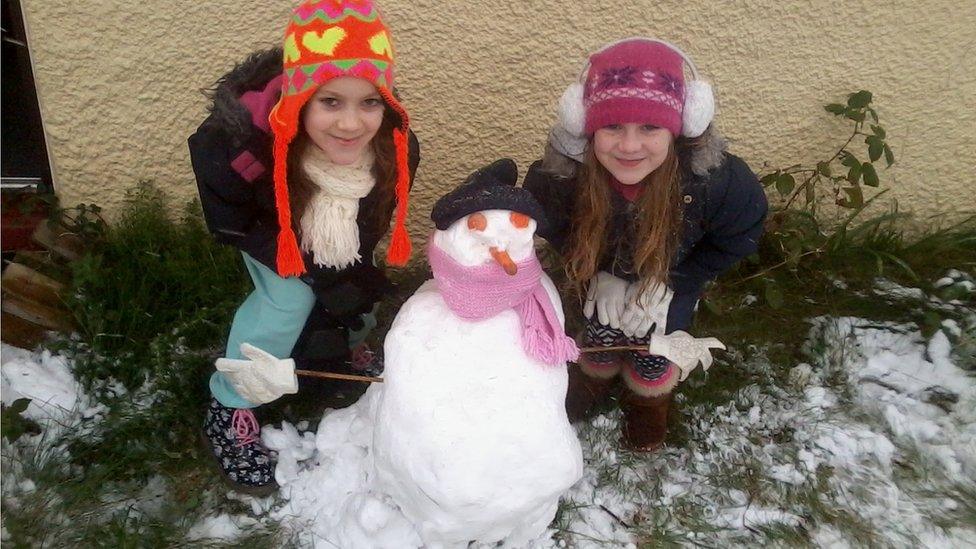 Two girls with a snowman.