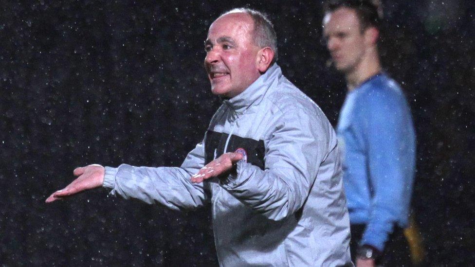 Cliftonville boss Tommy Breslin gives instructions in the Windsor Park rain