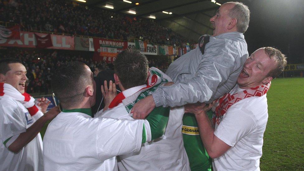 Cliftonville manager Tommy Breslin gets the traditional 'bumps' from his players during the after-match celebrations