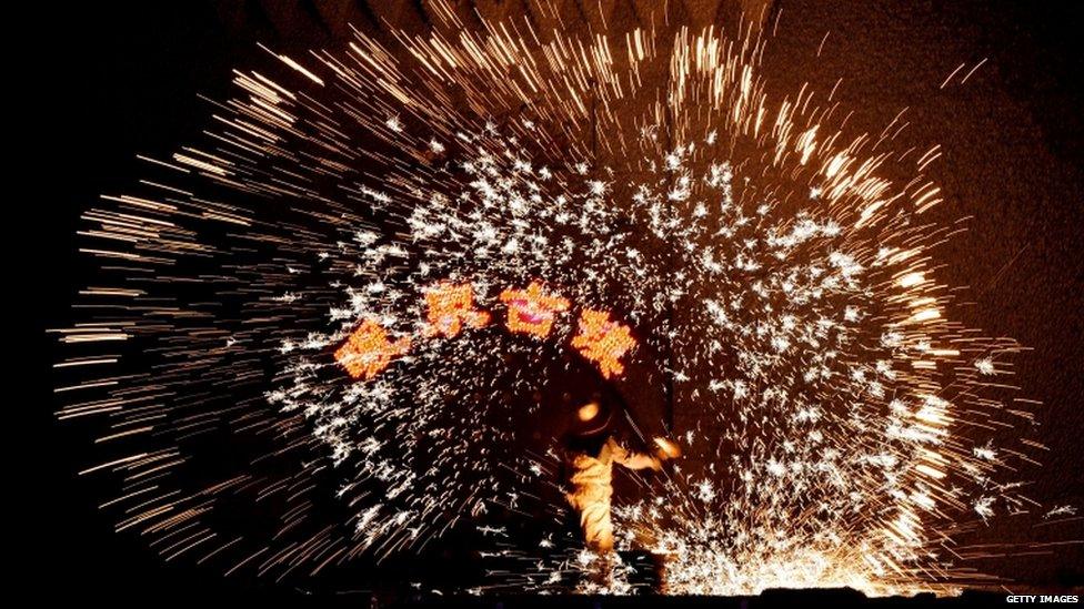 A blacksmith uses molten metal to create sparks during the Lantern Festival in Nuanquan in Heibei province.