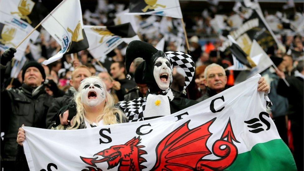 Swansea City fans show their support, in the stands prior to kick-off during the Capital One Cup Final match at Wembley Stadium,