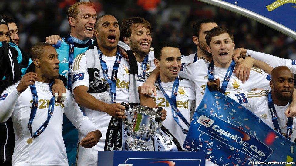 Swansea City players celebrate with the trophy after winning the English League Cup