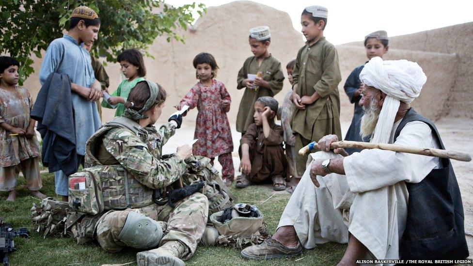 Photograph showing Captain Anna Crossley speaking Pashto in a Helmand compound