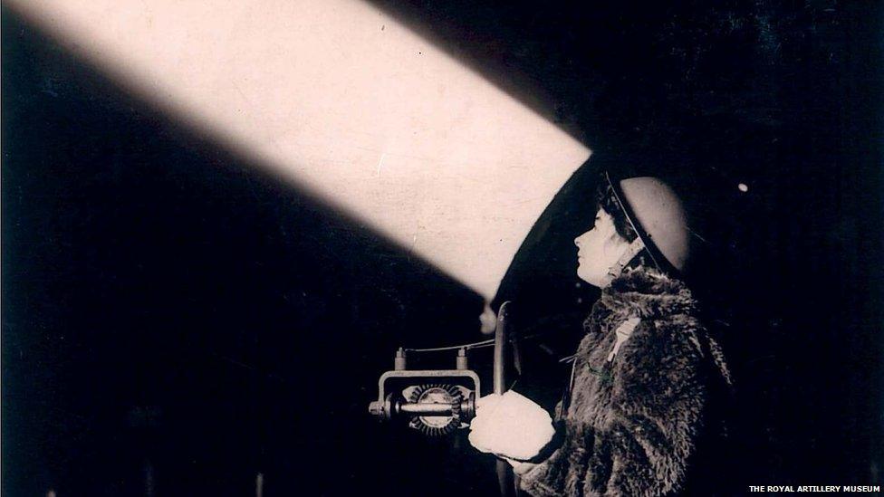 Archive photograph of a woman with searchlight at night