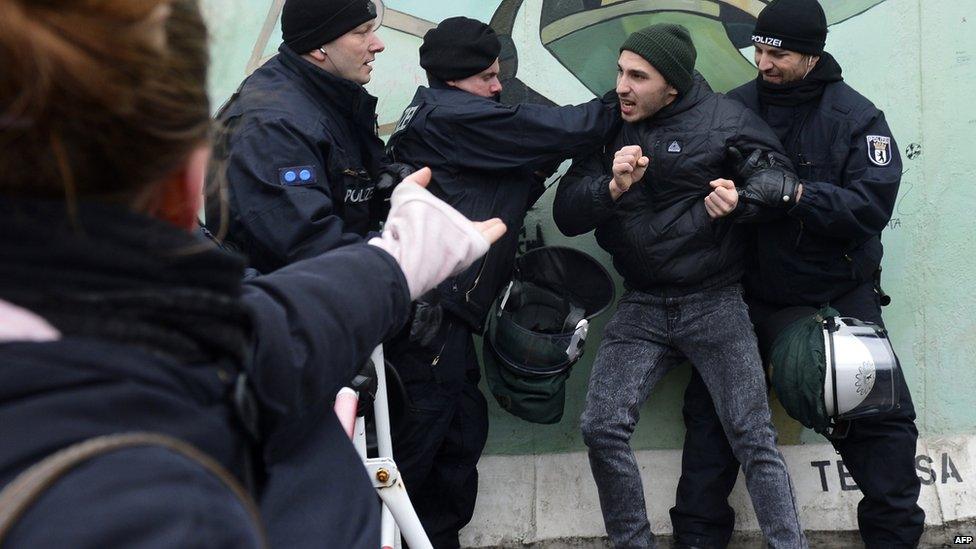 Protesters scuffle with police at the Berlin Wall
