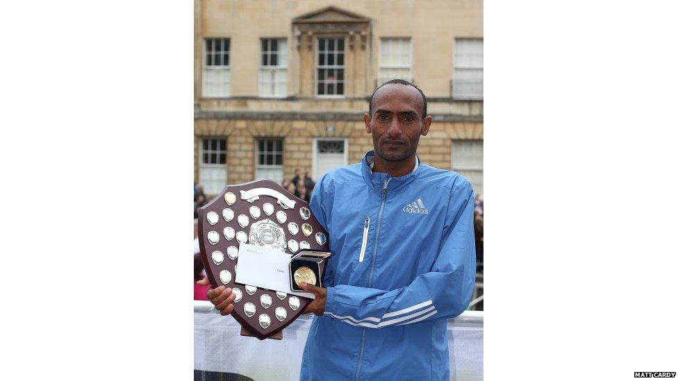 Ethiopian Tewodros Shiferaw holding his trophy and winner's medal