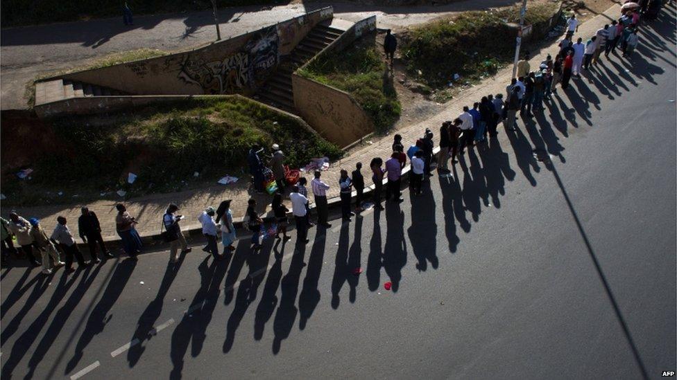 Voters stand in a long queue, just before voting is due to close, in downtown Nairobi, the Kenyan capital, on March 4, 2013 as Kenyans vote in general elections.