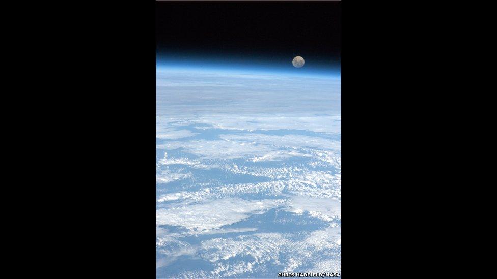 The moon rising over planet Earth