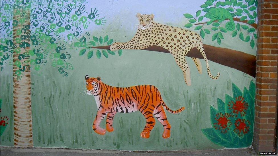 Mural of a leopard lying on the branch of a tree and a tiger on the grass below. Photo: Emma Scutt