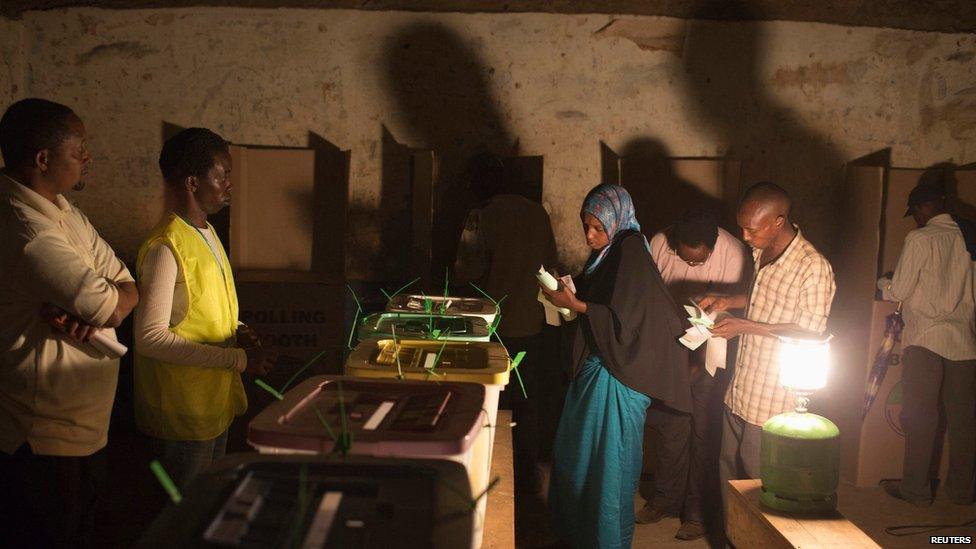 People cast their votes near the end of the day during the Kenyan general elections at the Wabera primary school in Isiolo, northern Kenya, 4 March 2013