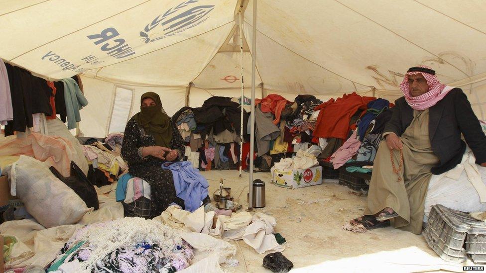 Refugees working on a second hand clothes stall in the camp