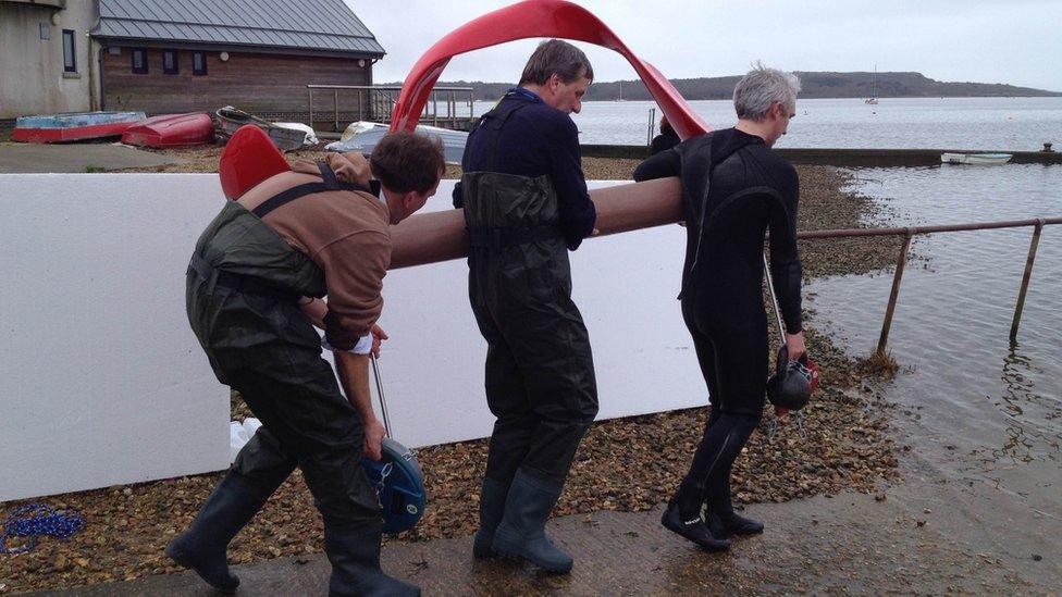 Red floating wavelength sculpture unveiled in Mudeford - BBC News