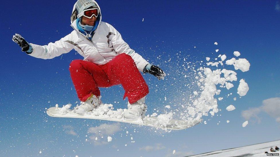 Teacher Kirsty Willett snowboards in the snow on the South Downs near Brighton in southern England