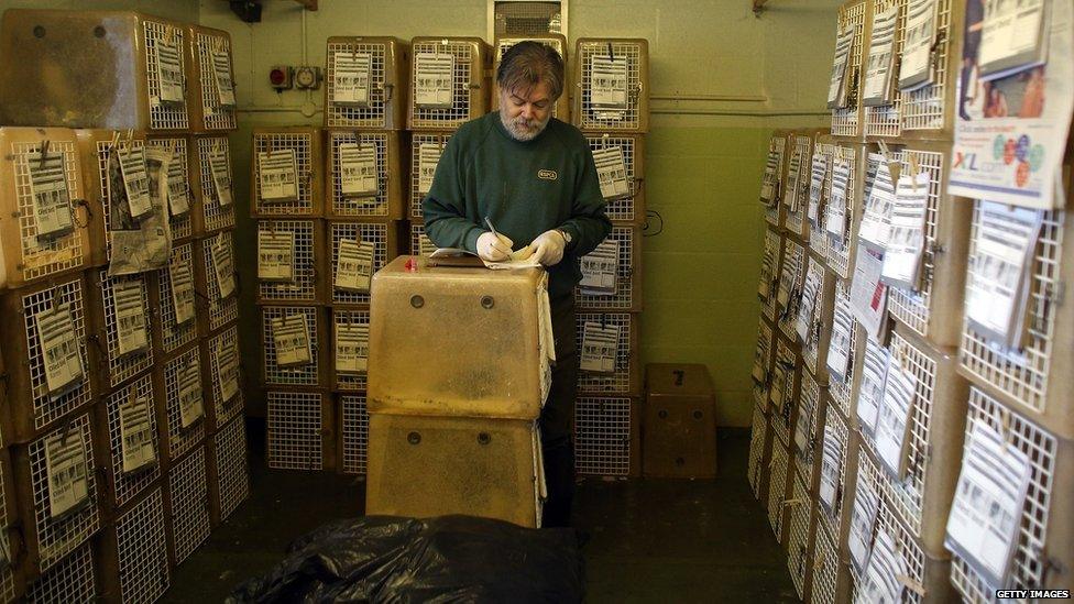 Wildlife assistant Mark Sinclair fills out a information form in front of cages full of rescued birds