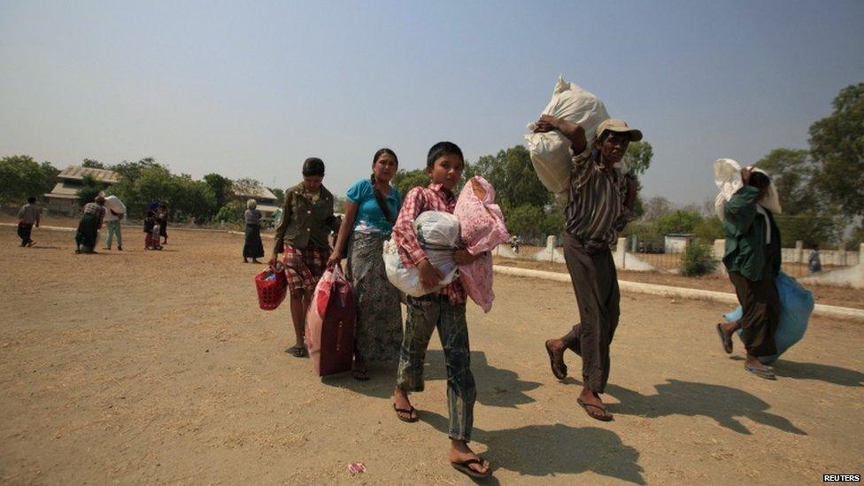Muslims carry their belongings as they arrive at a stadium amid riots in Meiktila, 22 March 2013