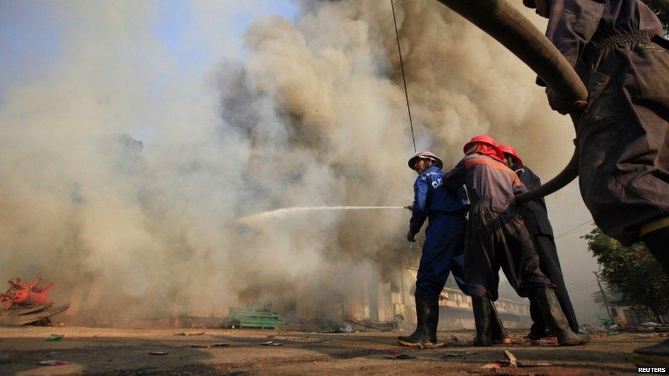 Firemen attempt to extinguish a fire during riots in Meiktila 22 March 2013