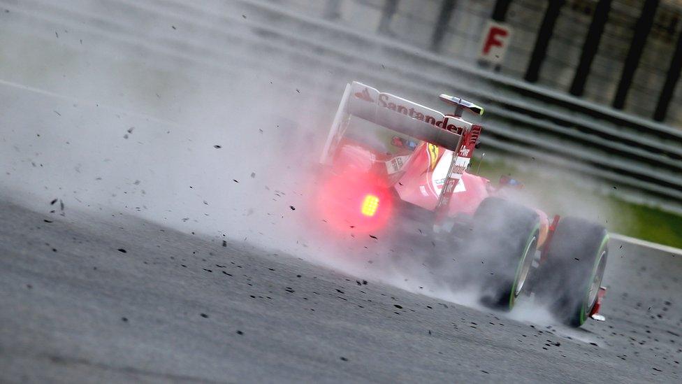 Felipe Massa drives through tyre debris and surface moisture