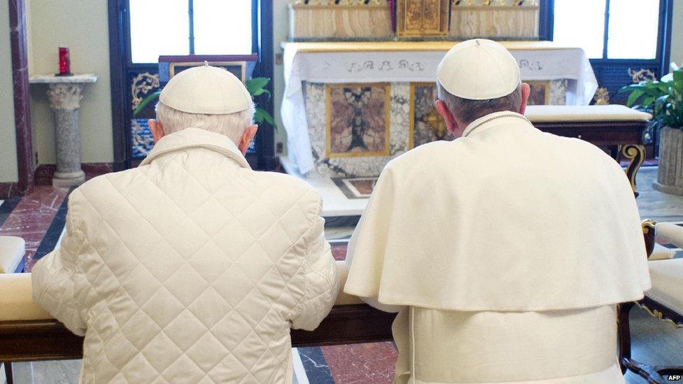 Pope Emeritus Benedict, left, prays with Pope Francis. 23 March 2013